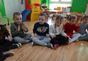 Grupa dzieci siedzi na podłodze
